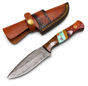 A fixed-blade knife with a patterned steel blade, a reddish-brown wood handle with colorful inlay, and a brown leather sheath, shown on a plain white background.